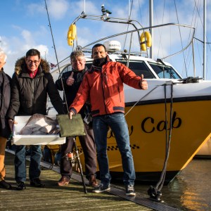a group of people standing on a boat posing for the camera