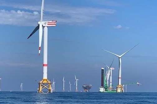 a windmill next to a body of water