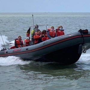 a group of people in a small boat in a body of water